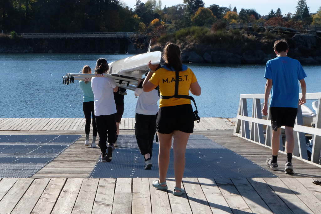 Juniors carrying boat to the water.