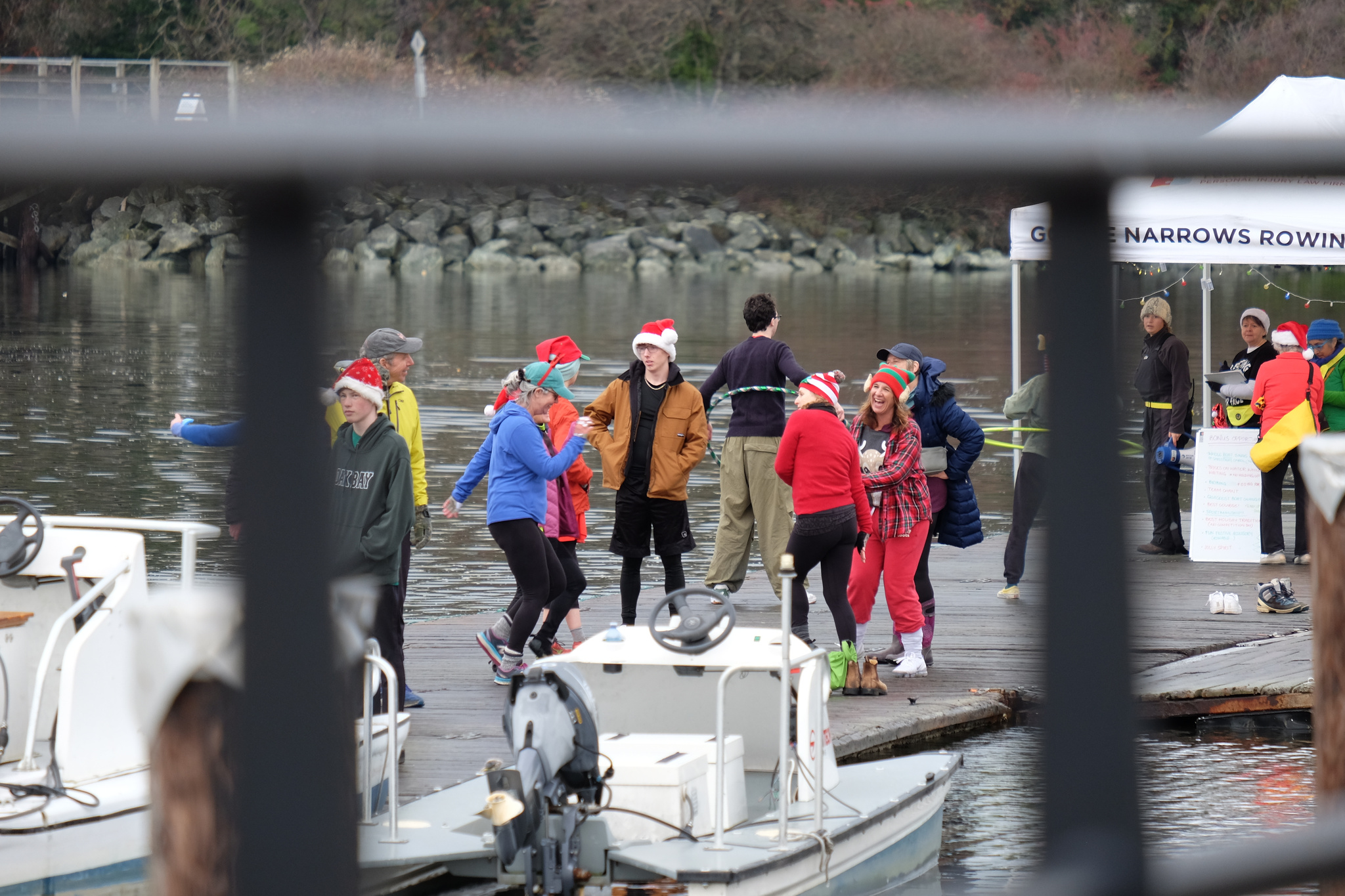 People dancing on the dock, viewed through the grid of a fence.