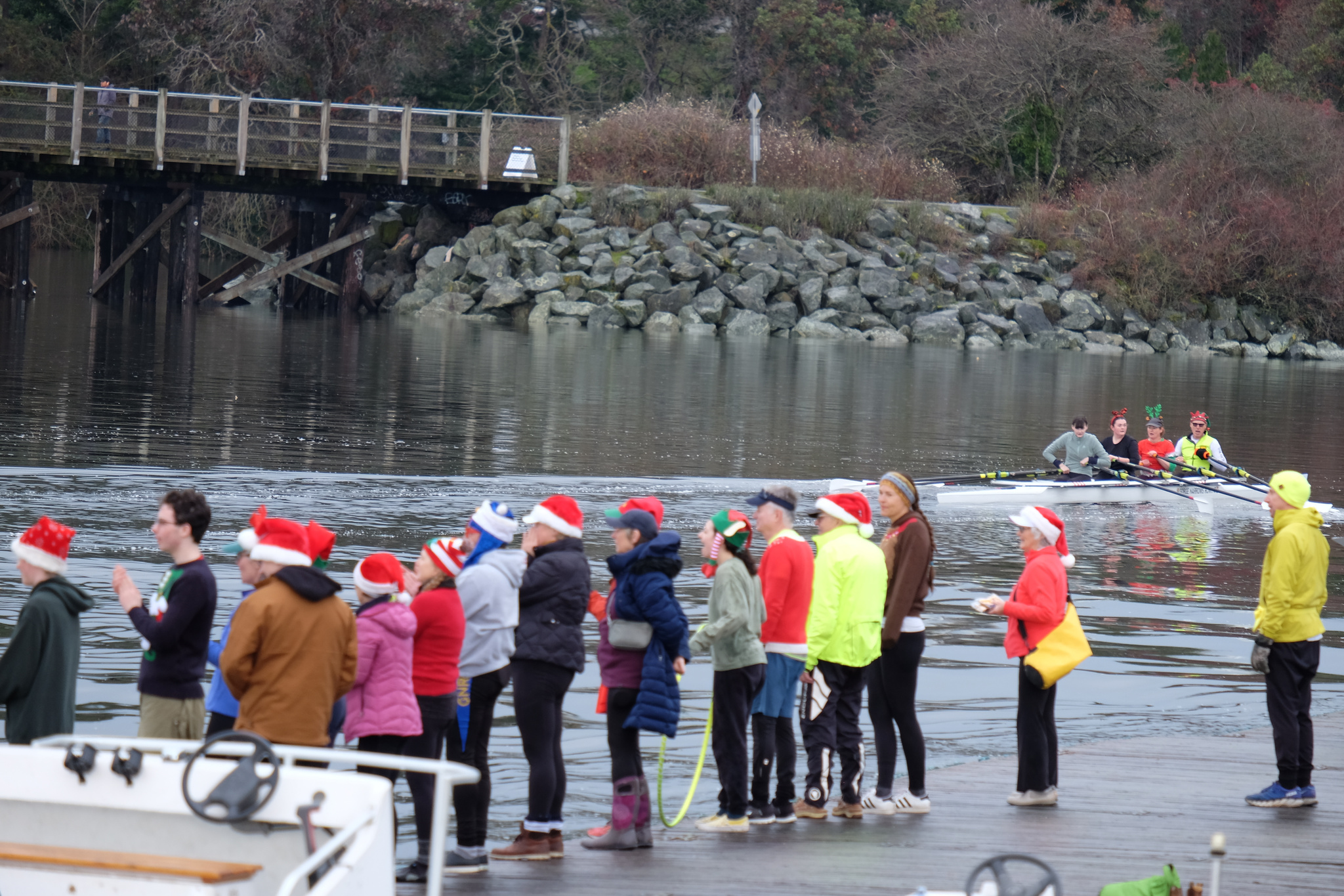 People, many wearing festive attire, cheer on the racers.