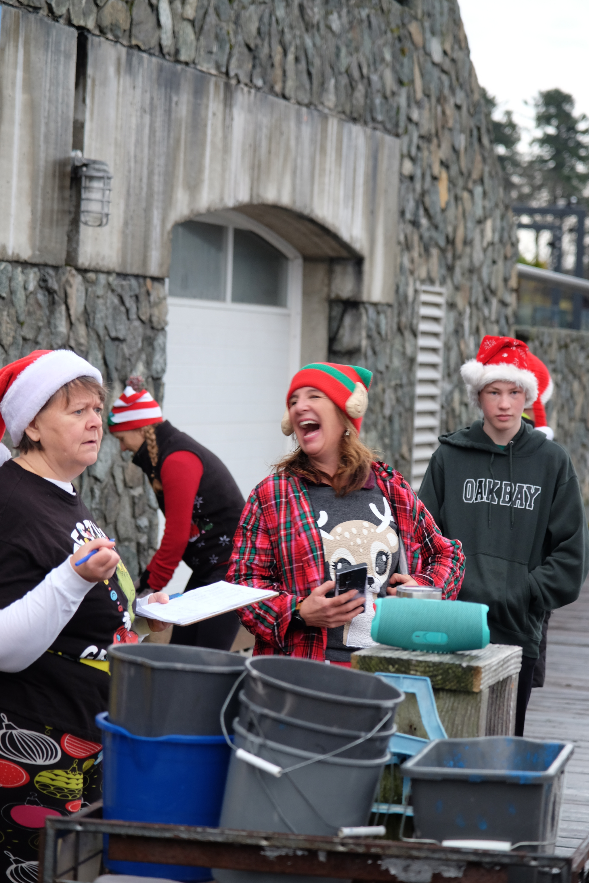 Four rowers in holiday hats on the dock.