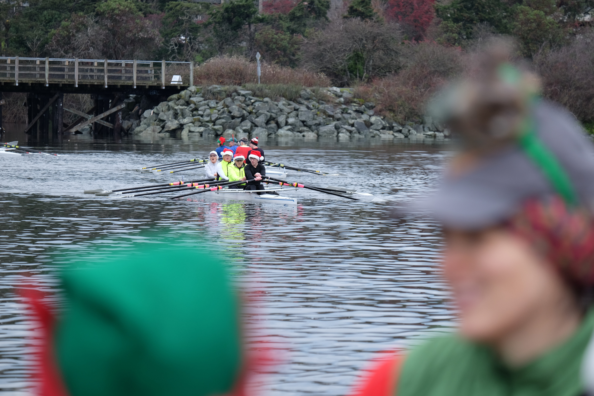 A quad on the water. In the background is the Selkirk Trestle. In the foreground are two people apparently dressed as elves.e