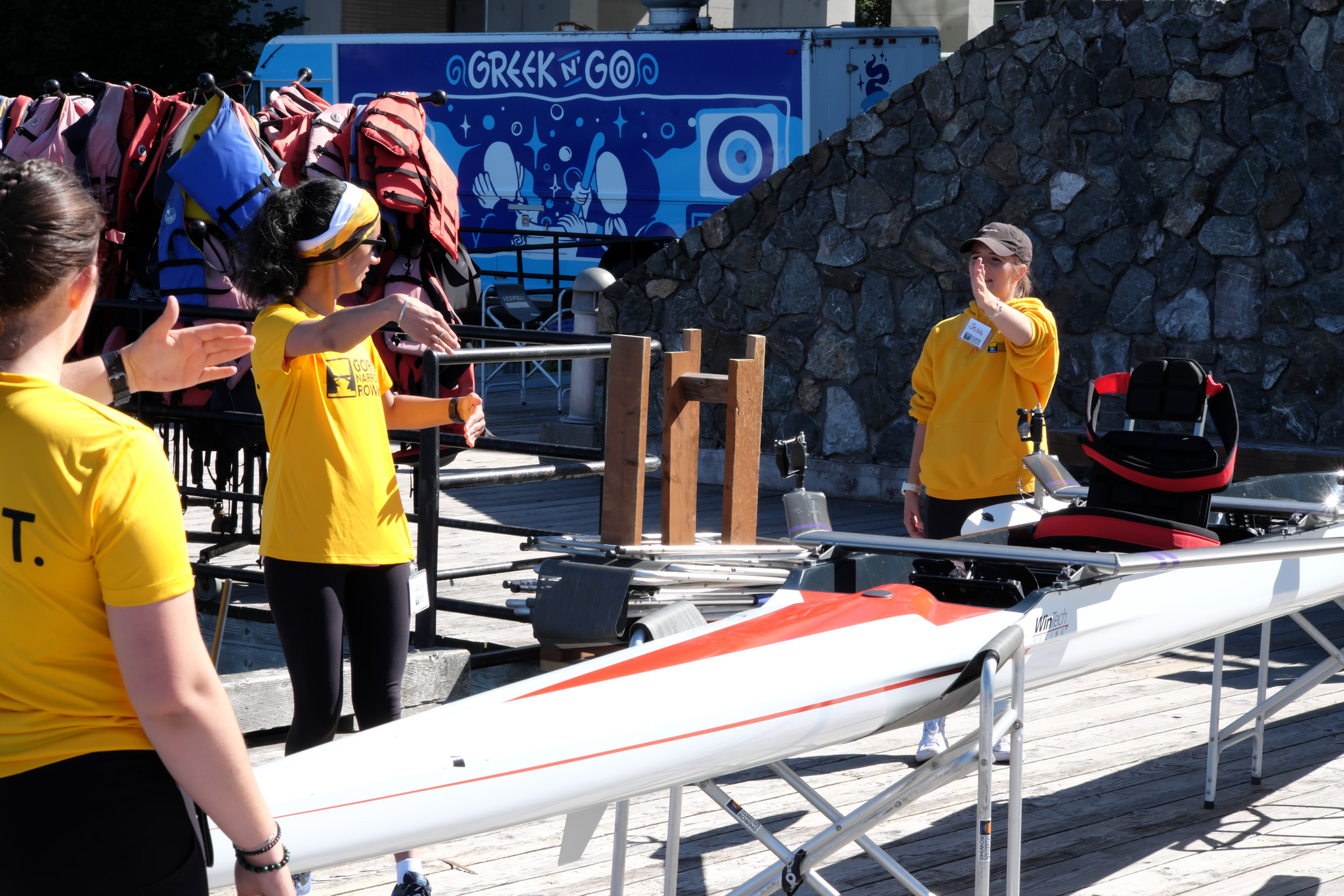 Some M.A.S.T. volunteers are talking around one of our boats that has had a para-rowing chair installed.