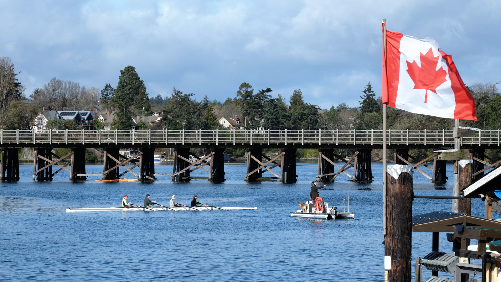 A quad and a coach boat. In the background is the Selkirk Trestle. In the foreground is a Canadian flag.