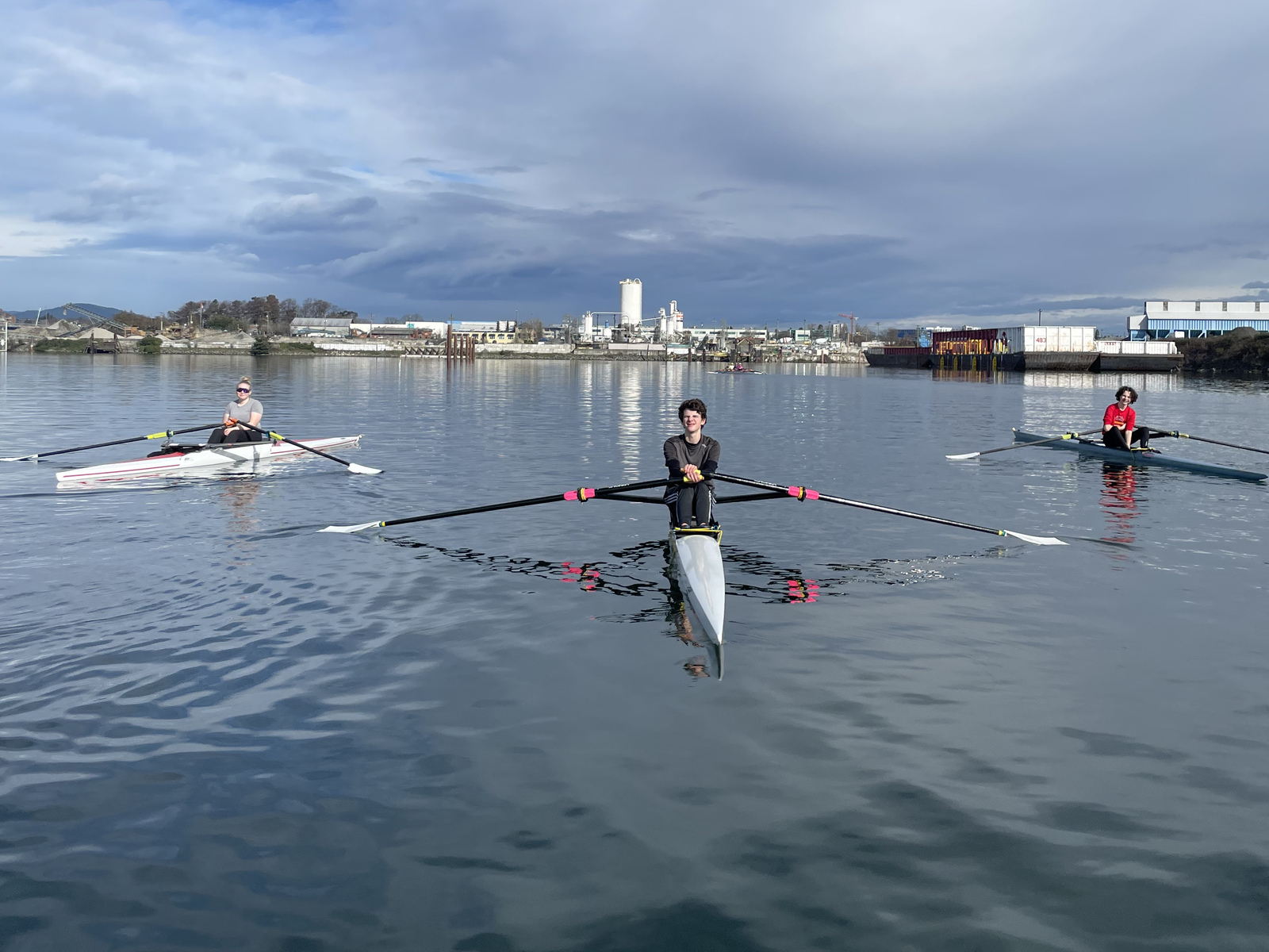 Three winter rowers in singles.