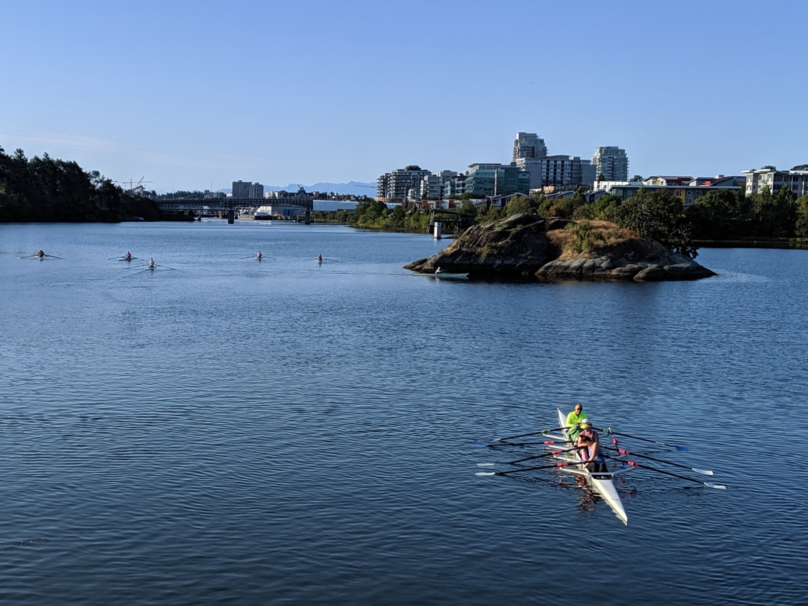 A quad rowing in the gorge in front of Halkett Island. In the background are smaller boats and the bay street bridge. The photograph was taken from the Selkirk Trestle.
