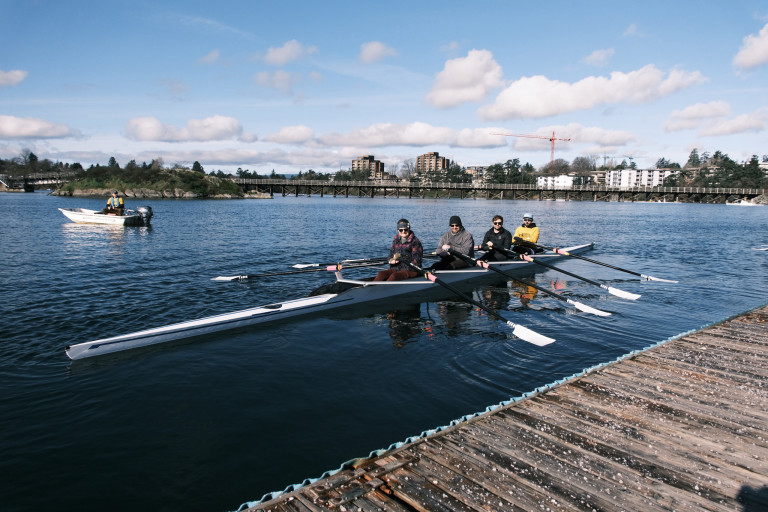 A quad that has just left the dock with a coach boat and the Selkirk Trestle visible in the background.