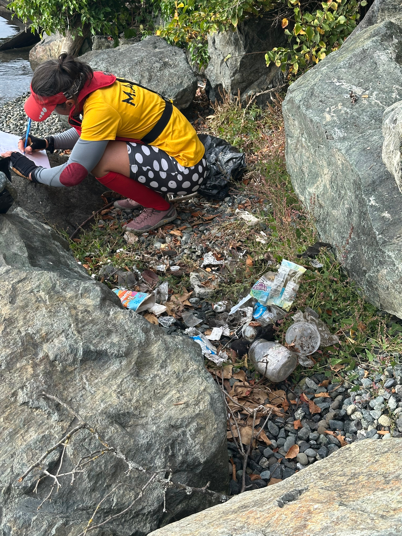 A GNRC volunteer picking up trash from the Gorge Waterway on November 17, 2024.