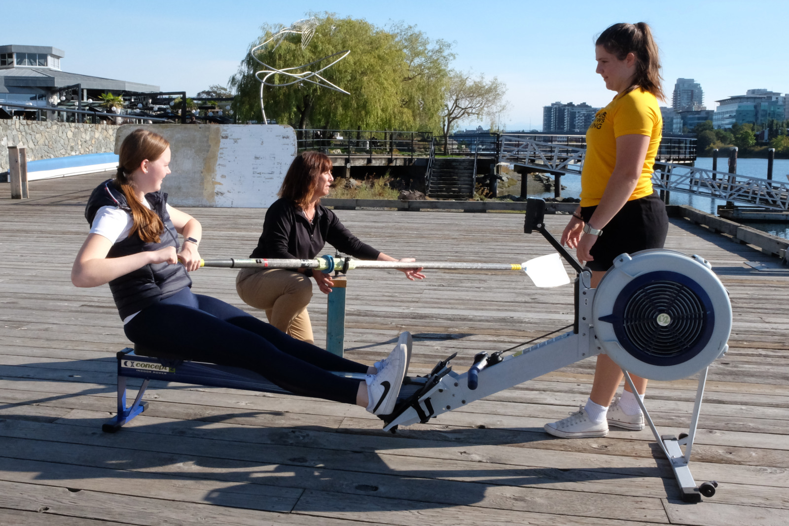A new youth rower learns the basics of a stroke on the dock.
