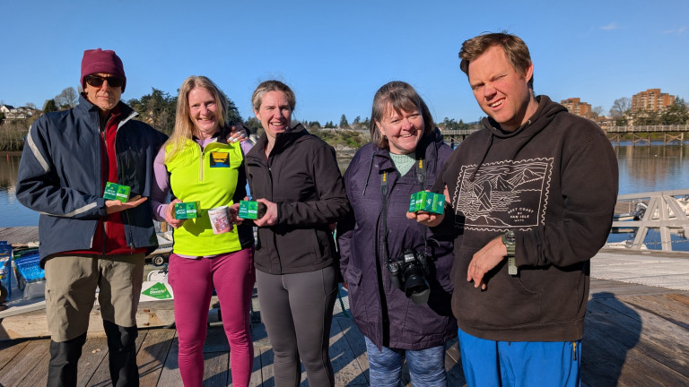 Four rowers and a volunteer on the dock after receiving their prizes!